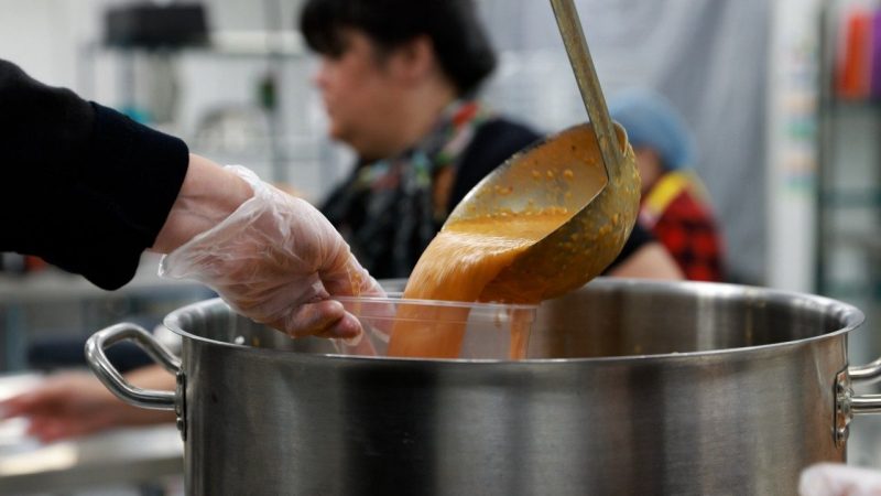 soup being ladled out of a large metal pot